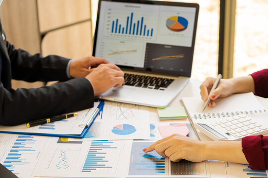 2 businessmen holding pens Point to the graph to calculate the analysis of the company's financial statements. Work with document graphs Concept image for the stock market, office, tax