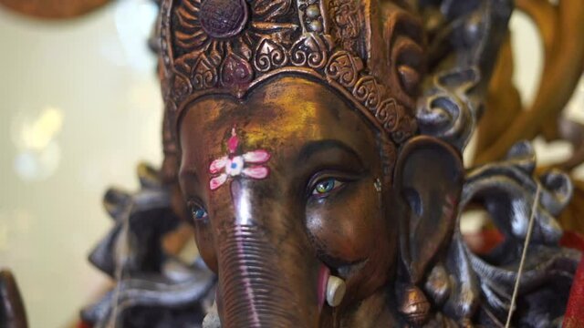 ganpati statue  of Indian god dark stone slow motion  face close up