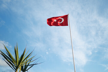National Turkish flag waving against blue sky.