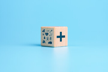 Health insurance concept, wooden cube with healthcare medical icons, blue background