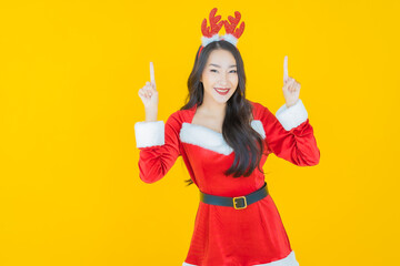 Fototapeta na wymiar Portrait young asian woman wear christmas costume with action on yellow background