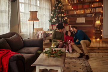 Parents and daughter during Christmastime at home