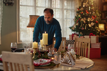 Fototapeta na wymiar Middle age man serving festive holiday table