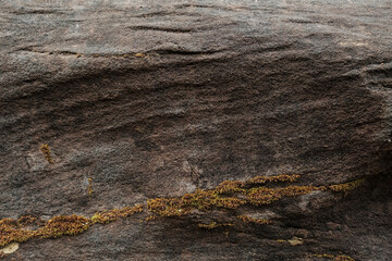 The texture of a natural stone wall with lichen.