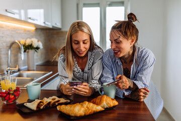 Smiling happy couple with cellphone and credit or bank card shopping online at home