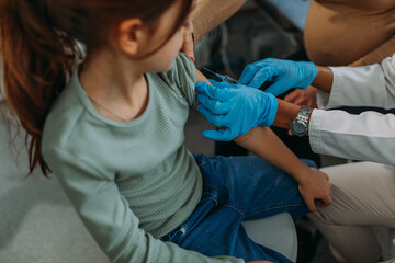 Obraz premium Girl patient in pediatrician's office getting vaccination