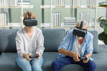 Caucasian old senior elderly grandparents couple wears virtual reality goggles headset. gray...
