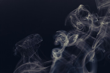 White smoke in front of the black background.	
