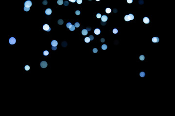 Bokeh blue lights background. Blurred festive Christmas lights on a black background