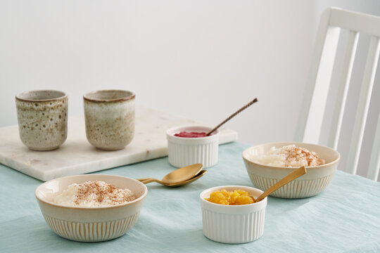 Lifestyle Holiday Sunday Morning Breakfast Or Lunch With Two Bowl Of French Rice Porridge Dessert. Rice Pudding. Comfort Winter Food. Table, Chair In Living Room Or Kitchen, Linen Pastel Tablecloth