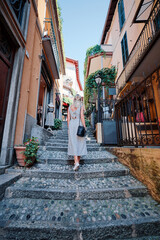 Fototapeta na wymiar Travel and active lifestyle concept. Young traveller woman walking in old italian town.
