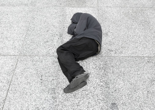 Homeless man sleeps on the ground in the city center