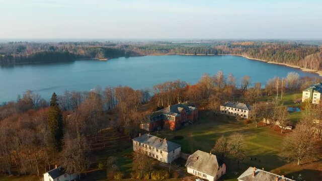 Old Red Brick House, Katvari Manor in Latvia and Katvaru Lake in the Background. View From Above. In the Manor Territory Is a Big Park With Hundred-year Old Linden. Aerial Dron Shot 4K Resolution