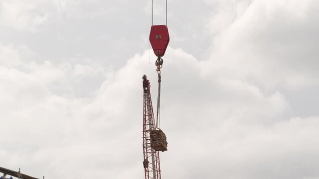 Tower Crane Hook Block And Hook Lifting Materials At Construction Site. low angle