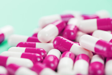 Pink medical pills on a black background.