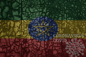 flag of ethiopia on a old metal rusty cracked wall with text coronavirus, covid, and virus picture.