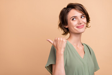 Photo of happy joyful young woman smile dream point finger empty space sale isolated on beige color background