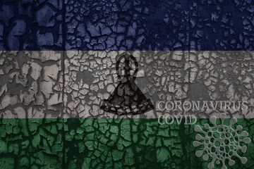 flag of lesotho on a old metal rusty cracked wall with text coronavirus, covid, and virus picture.