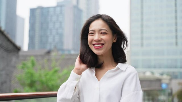 Attractive happy young asian woman in white shirt walking in the urban city street confidence young businesswoman walking slow motion clip