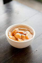 Close-up A bowl of Sala seedless in syrup with ice on the wood table.