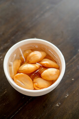 Close-up A bowl of Sala seedless in syrup with ice on the wood table.