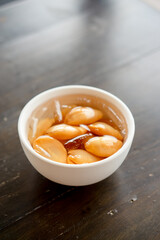 Close-up A bowl of Sala seedless in syrup with ice on the wood table.