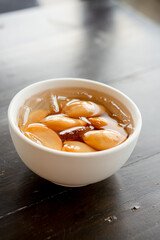Close-up A bowl of Sala seedless in syrup with ice on the wood table.