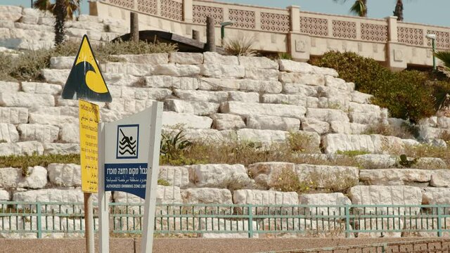 Warning signs against drowning and tsunami on a beach in Israel
