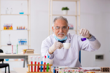 Old male chemist in drug synthesis concept