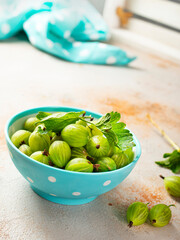 Fresh gooseberries in blue bowl. Top view.