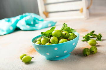 Fresh gooseberries in blue bowl. Top view.