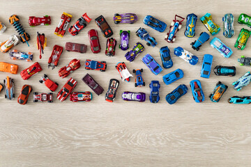 Top view random collection of model sport car toy hot wheels on wooden floor