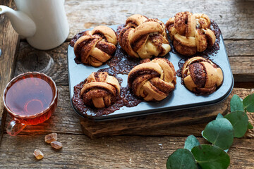 Cinnamon rolls, round yeast buns. Side view, wooden background.