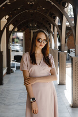young woman in beige dress on the street