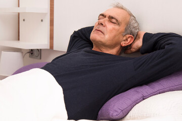 Fototapeta premium man relaxed and lying in bed at home