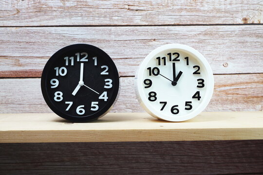 Clocks with time zone of different country on wooden shelves background