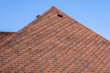 The roof is made of brown bituminous tiles.