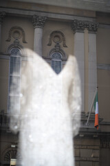 Wedding dress in store window with Irish flag and building reflected in the background