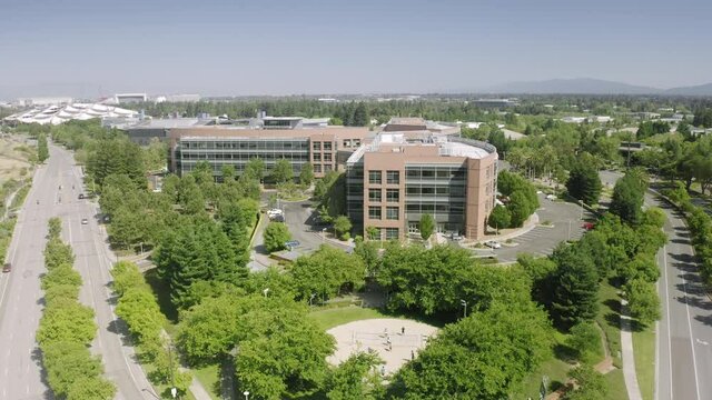 Aerial view of spectacular work environment in Mountain View, California. Google Headquarters complex, surrounded by lush green vegetation, as seen from above. High quality 4k footage