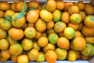 Wooden crate filled with fresh tangerines. Top view.