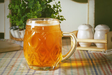 Mug of light beer on a table in the pub or cafe with white background