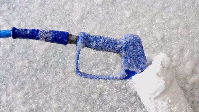 Car wash gun frozen and covered with ice and snow. 