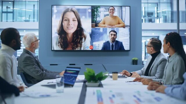 Video Conference Call in Office Boardroom Meeting Room: Executive Directors Talk with Group of Multi-Ethnic Entrepreneurs, Managers, Investors. Businesspeople Discuss e-Commerce Investment Strategy