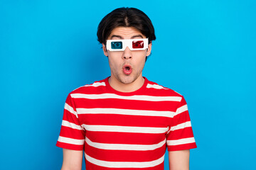 Photo of sweet shocked young guy dressed red t-shirt 3d eyewear isolated blue color background