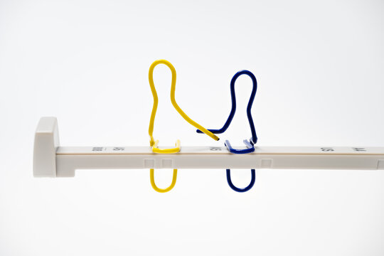 Lunch atop a Skyscraper – two paper clips holding hands on the stop rail of an office punch.