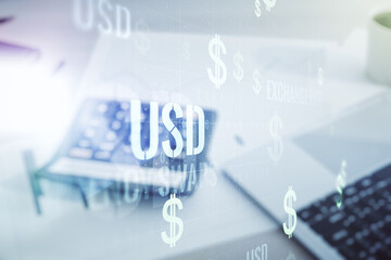 Double exposure of virtual USD symbols hologram on blurry calculator with laptop background. Banking and investing concept