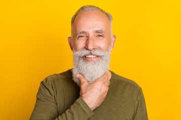 Photo of handsome elderly grandpa touch well-groomed beard wear green shirt isolated yellow color background