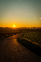 Obraz premium Goldener Sonnenaufgang in Deutschland, Feldweg, Ländlicher