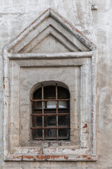 Fototapeta na wymiar latticed windows and a fragment of the facade of an ancient brick building