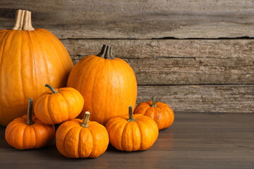 Fresh ripe pumpkins on wooden table, space for text